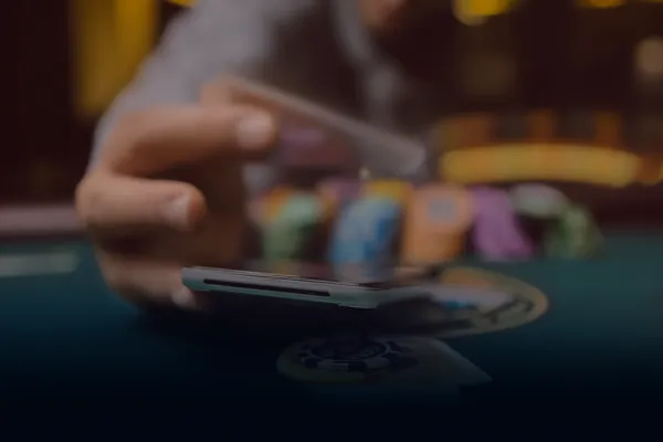 A person using their device against a moody casino-themed background, illustrating the smooth re-entry process at TKPKK.